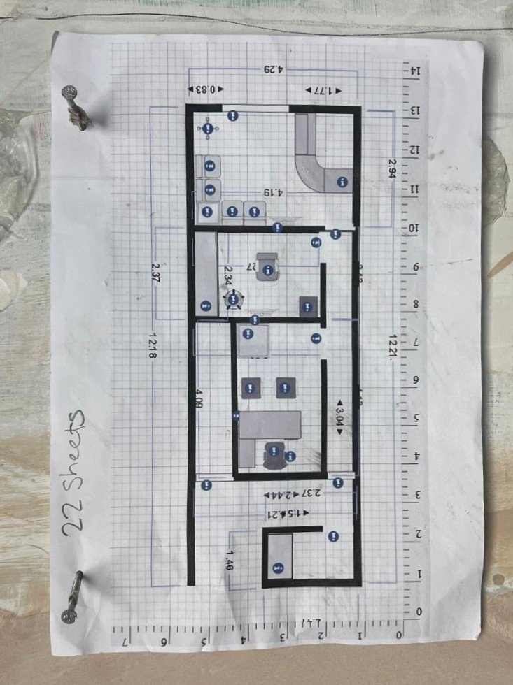 Printed floor plan for the Audibility clinic pinned to the wall during the August 2024 build.